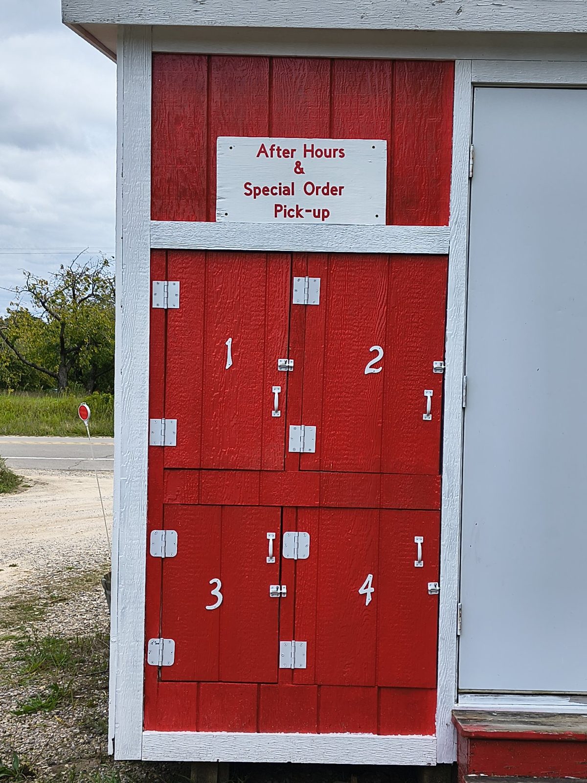 The numbered after-hours pickup doors at the back of the farm stand